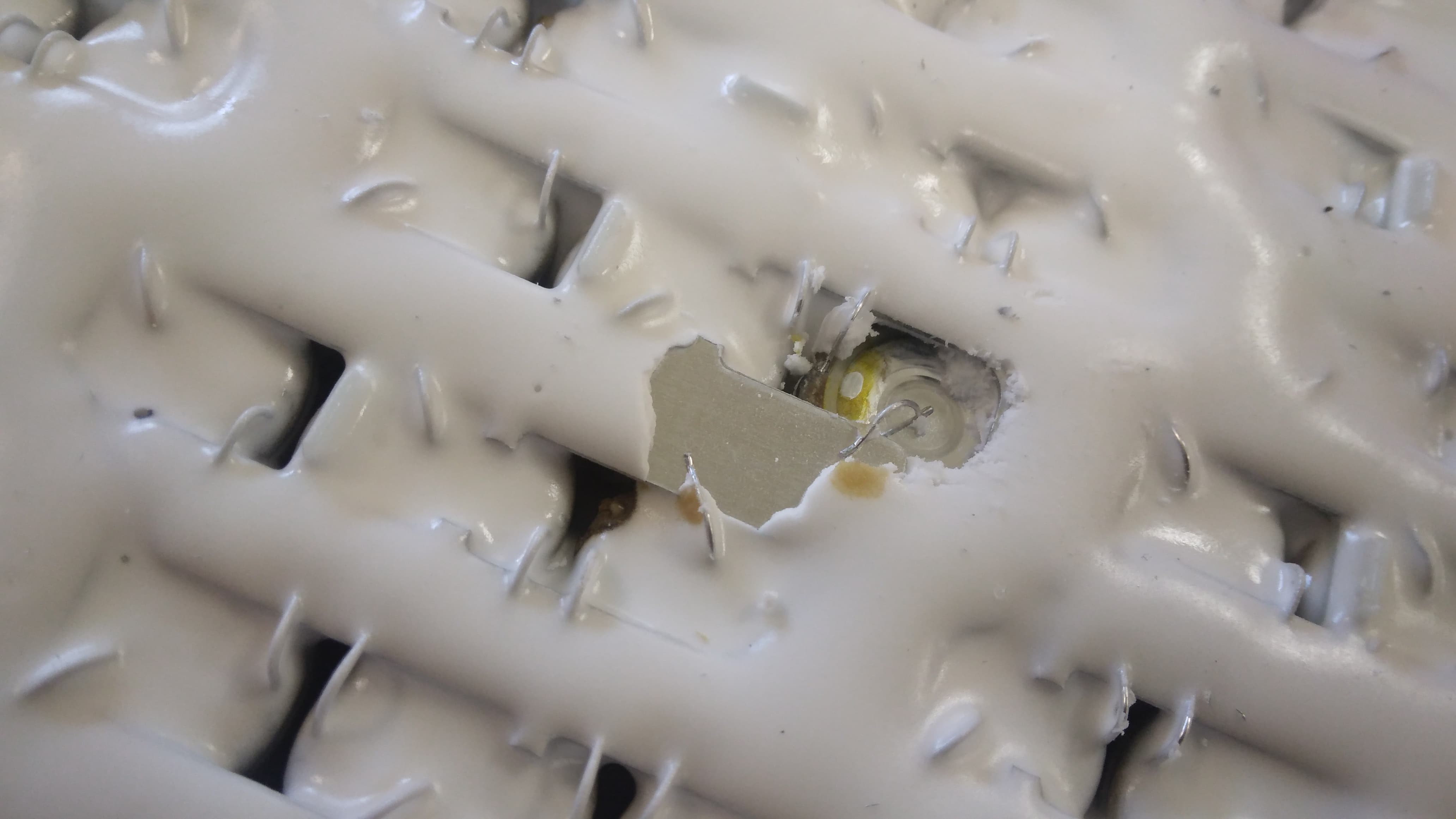 Under the potting: the top of a 21700 cell with electrolyte traces